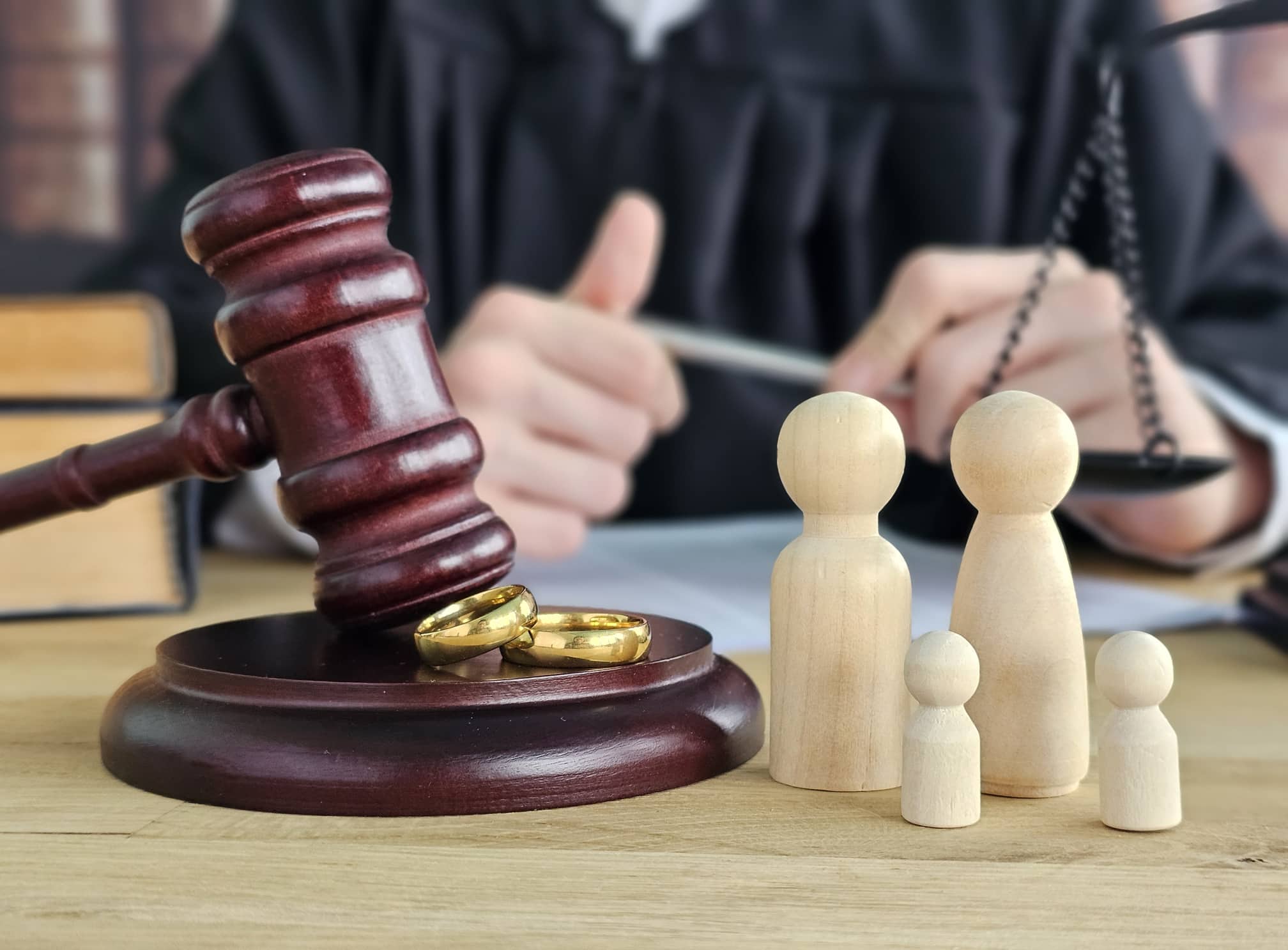 Gavel, wedding rings, and wooden family figures